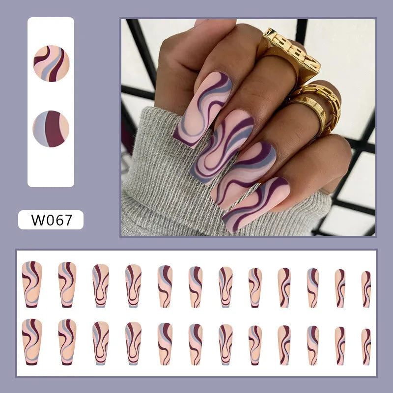 Close-up of finished W067 wave line design nail stickers with jelly glue tube on a manicured hand.