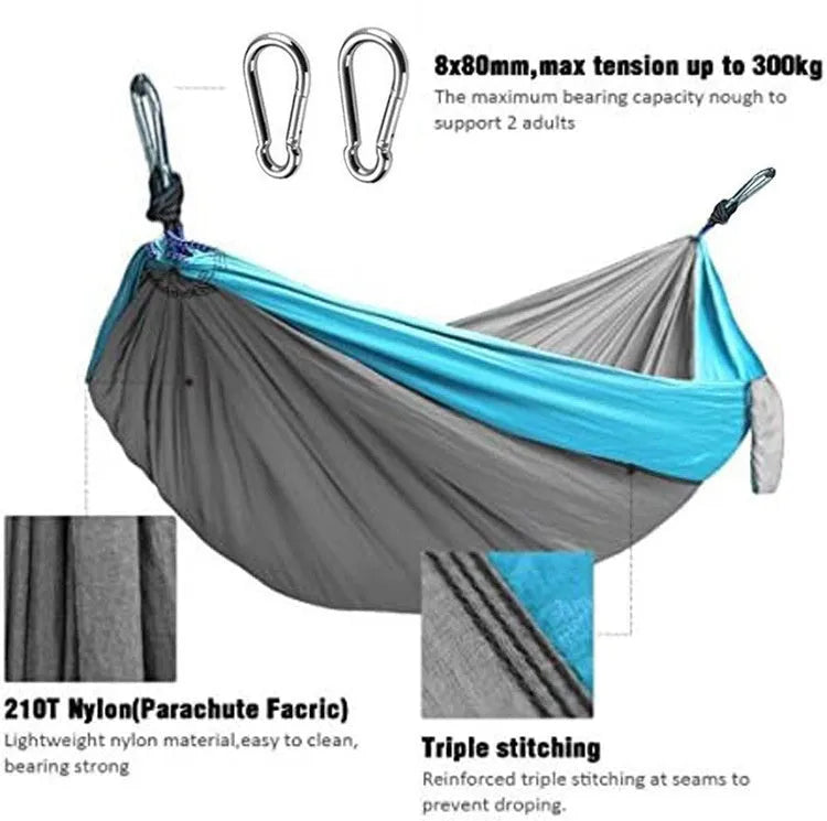 Blue outdoor camping hammock made from parachute nylon fabric, hanging between two trees.