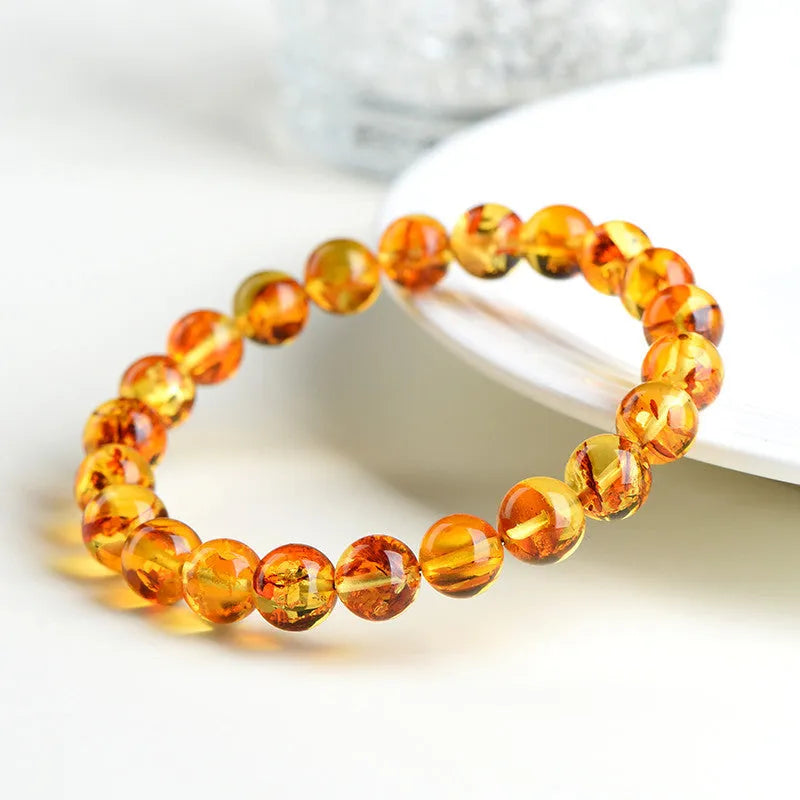 Natural yellow piebald amber bracelet with polished geometric beads on a wrist.
