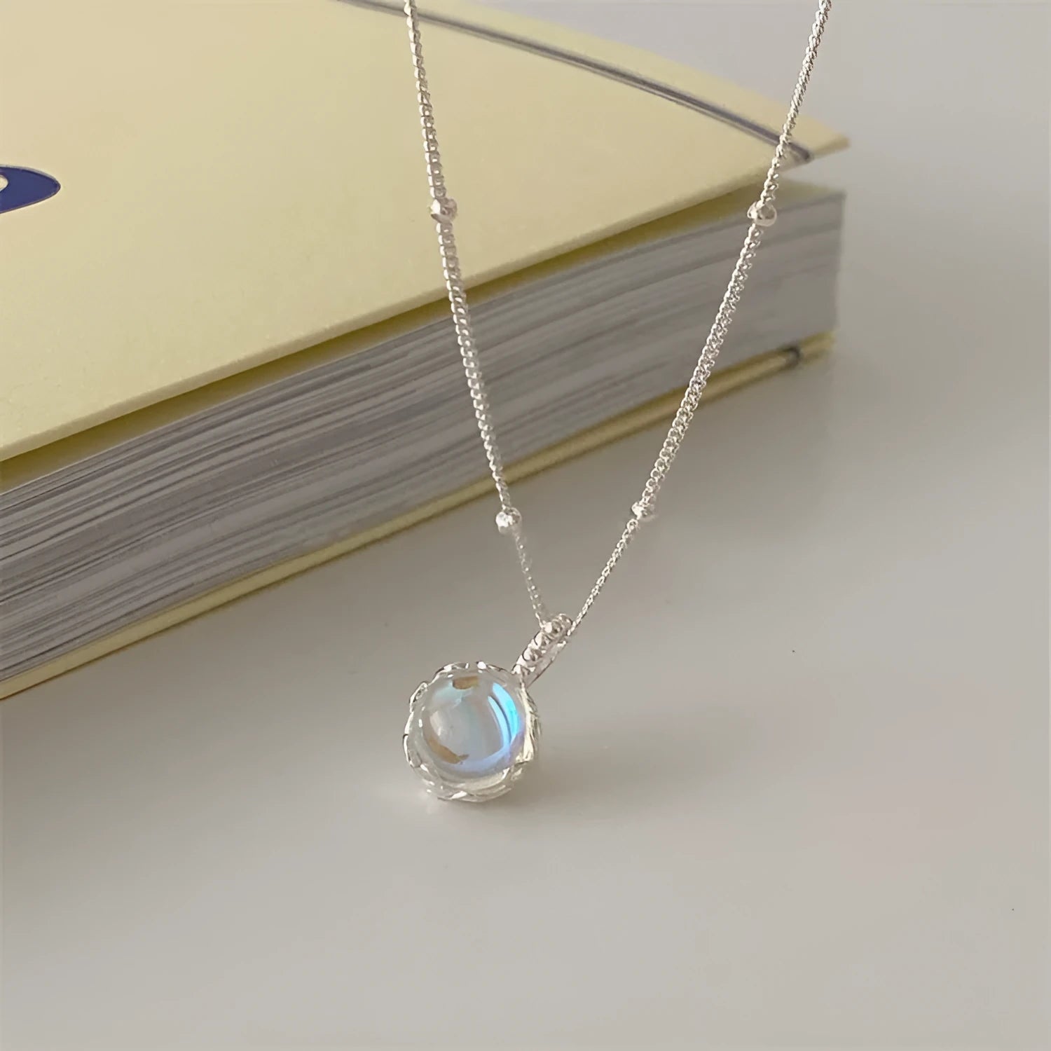 Women's sterling silver geometric stone pendant necklace on a curb chain, adjustable length.