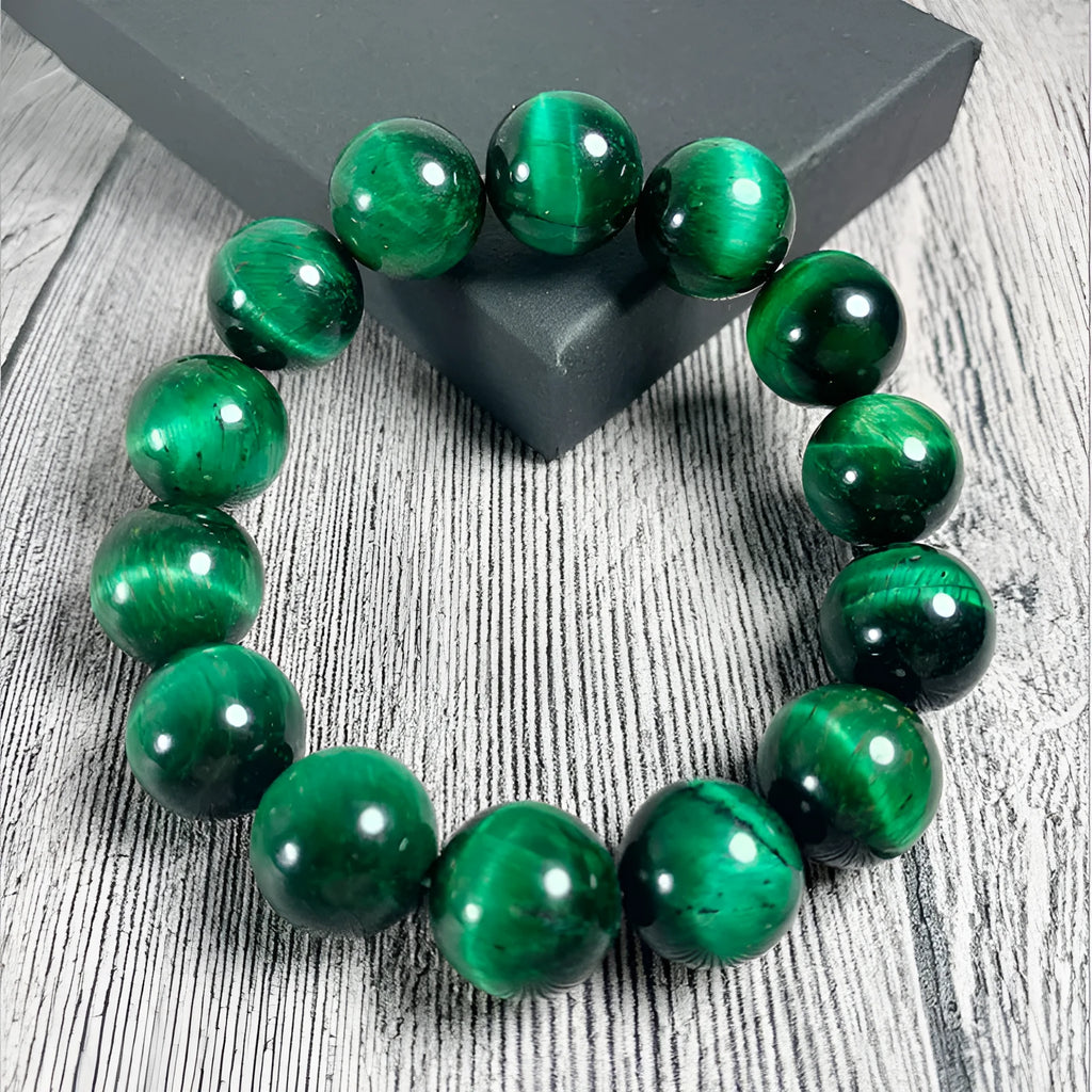 Natural green tiger eye stone bracelet with geometric polished beads on a wrist.