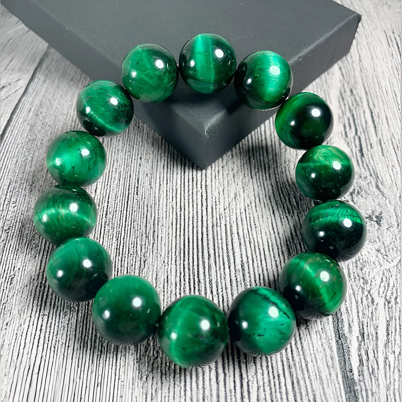 Natural green tiger eye stone bracelet with geometric polished beads on a wrist.