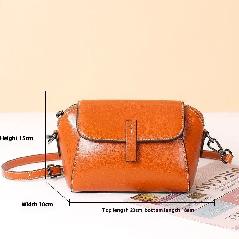 Brown women's genuine leather messenger bag with cross-body strap, showing outer sandwich pocket and visible sewing detail.