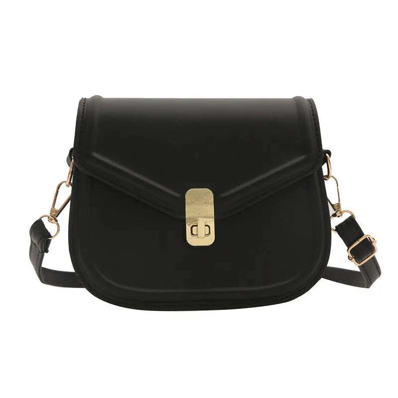 Men's soft black PU leather clamshell messenger bag in a horizontal square shape on a table.
