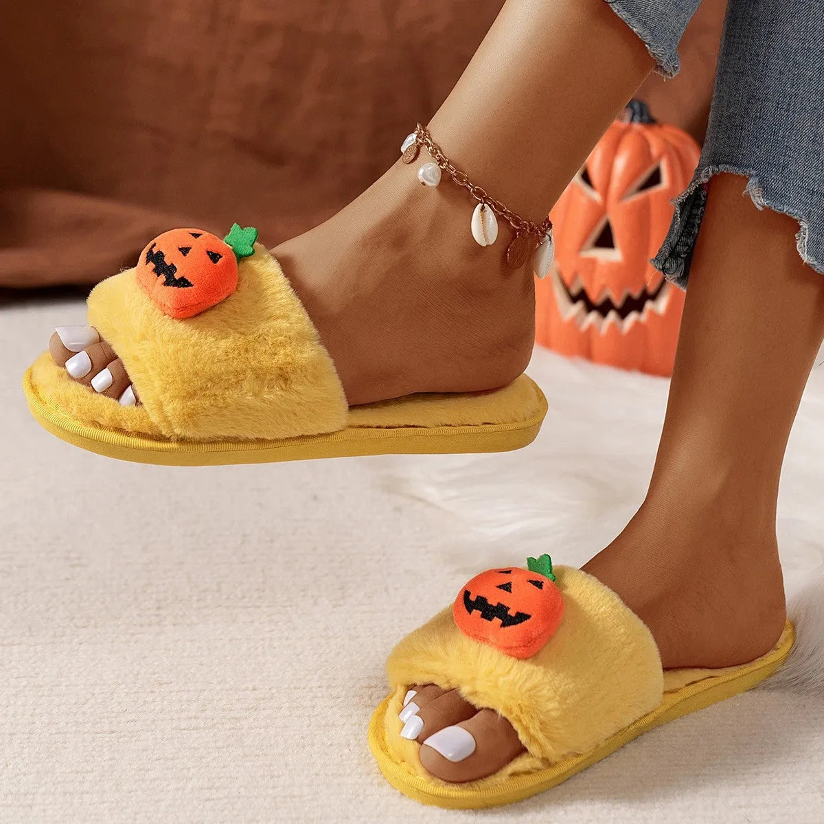 White and yellow pumpkin plush open toe slippers with cartoon Halloween design on synthetic fur