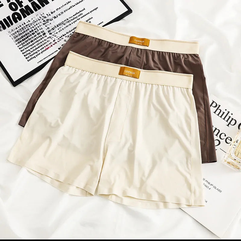 Three pairs of men's solid colour ice silk briefs on a grey background.