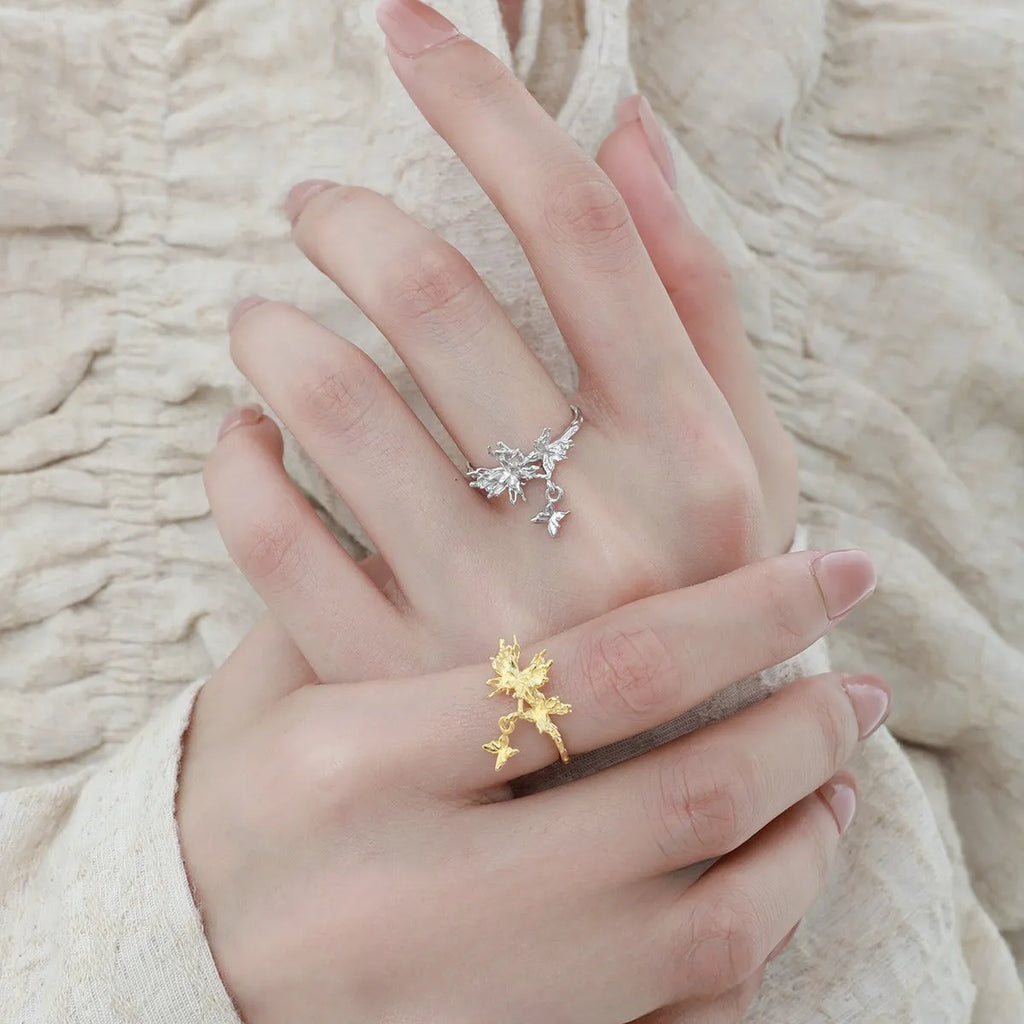 Women's adjustable silver ring with a wild butterfly design, shown in white gold and 18K gold colour finishes.