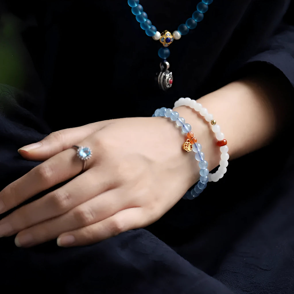 Women's crystal bracelet with ice translucent aquamarine 8mm round beads and sequin detailing on a white background.