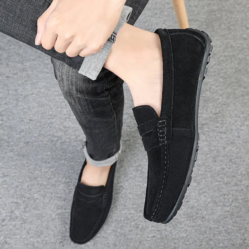 Men's solid colour suede slip-on loafers with a round toe and flat rubber sole.