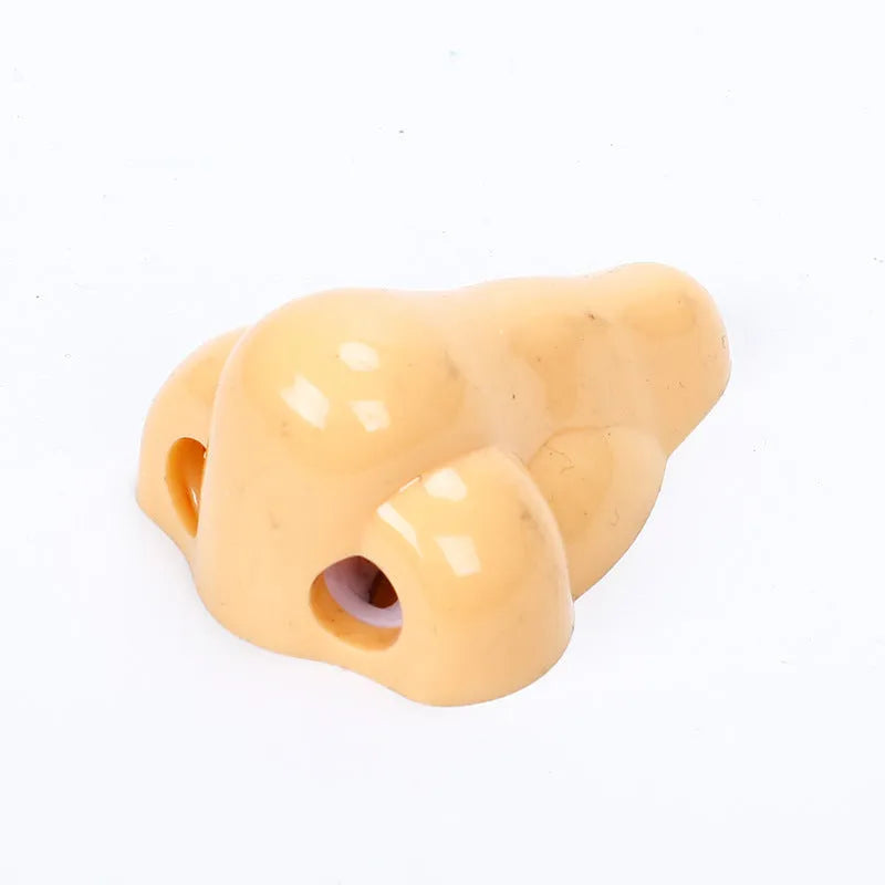 Flesh coloured plastic manual pencil sharpener with a geometry shape and large nostril opening.