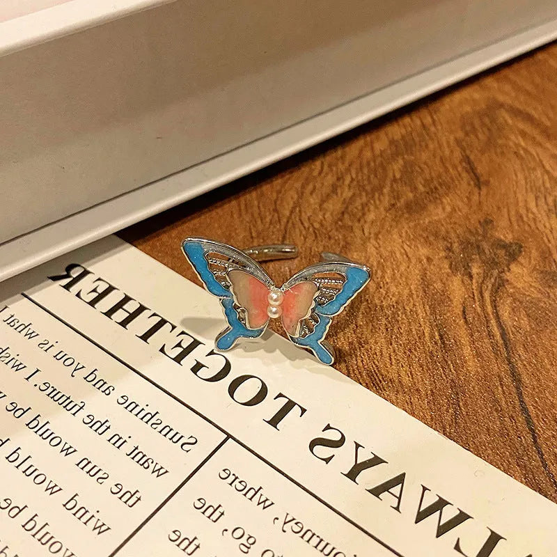 Copper butterfly women's ring with drip oil finish in an open-loop design.