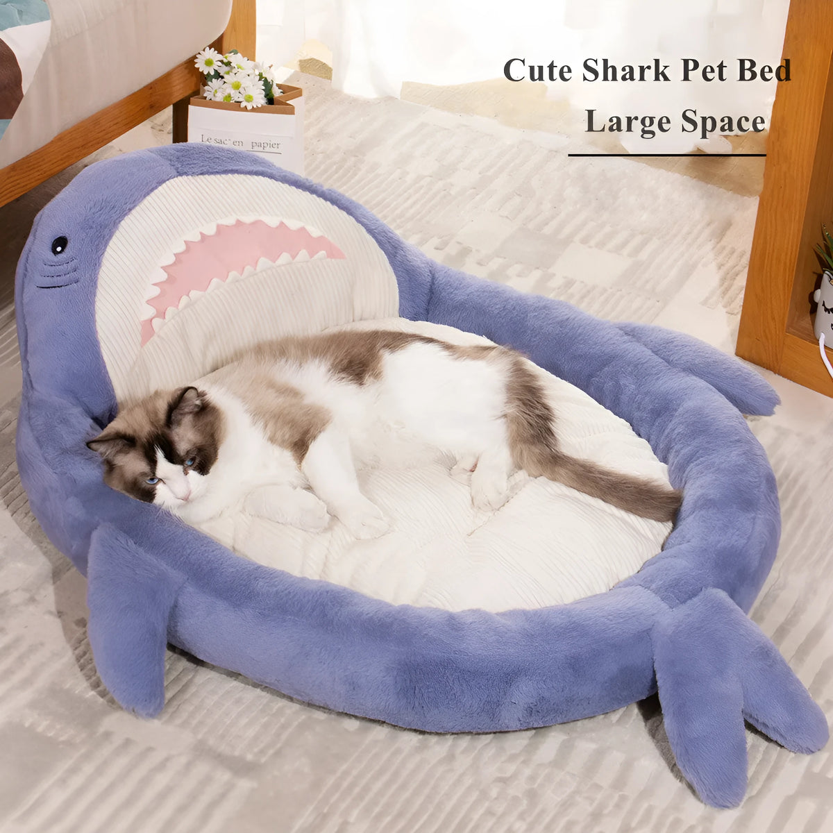 Blue shark pattern pet bed cushion for dogs or cats on a wooden floor.