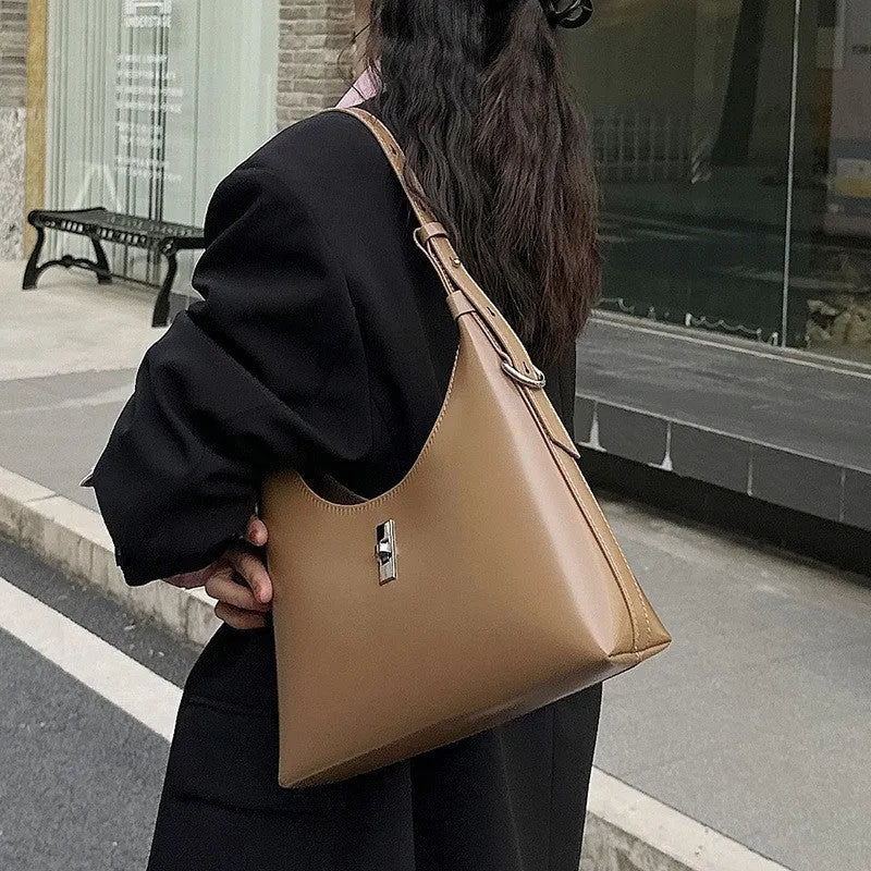 Soft genuine leather dumpling-shaped crossbody bag in apricot with sewing thread detail.