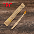 Ten bamboo toothbrushes with coloured handles and charcoal bristles laid out side by side.