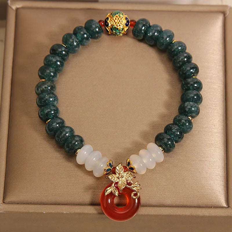 Women's blue water jade and red agate bracelet with peace buckle closure and rhinestone details