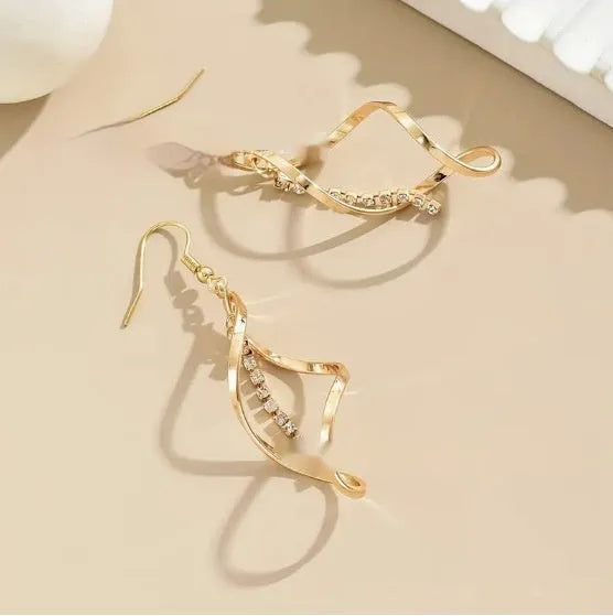 Gold geometric spiral earrings with ellipse design elements on alloy construction