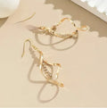 Gold geometric spiral earrings with ellipse design elements on alloy construction