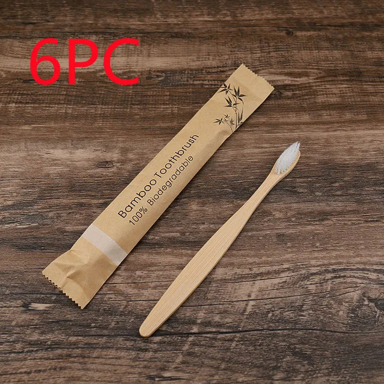 Ten bamboo toothbrushes with coloured handles and charcoal bristles laid out side by side.