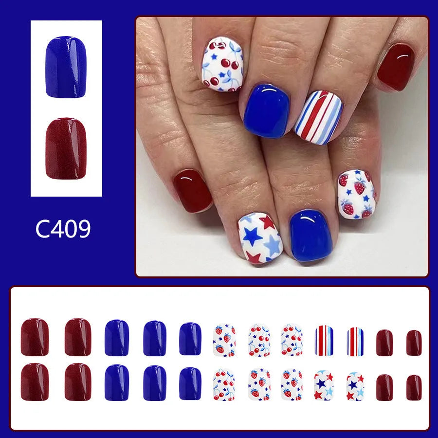 Short glossy red and blue strawberry cherry pattern false nail stickers laid out.