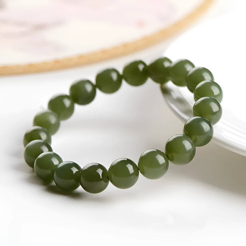 Polished Hetian jade ball bracelet showing spherical beads in ice-like clear water colour on a wrist.