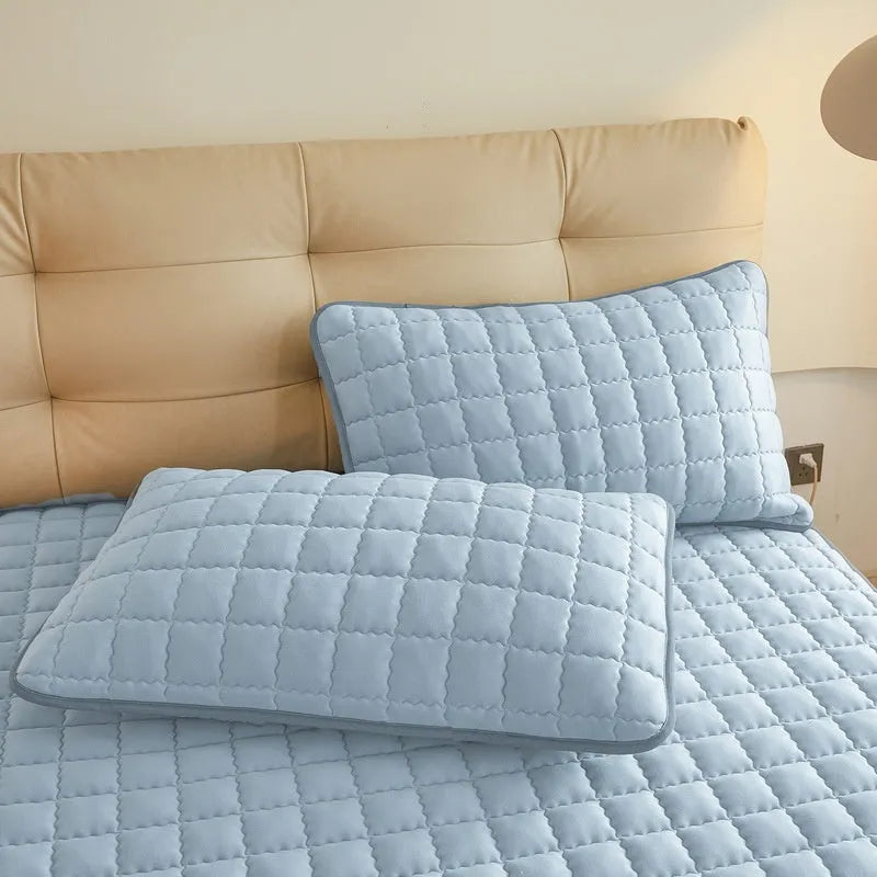 Blue washed cotton waterproof fitted sheet with elasticated corners on a mattress.