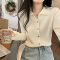 Loose fit beige viscose knitted cardigan top with long sleeves on a hanger