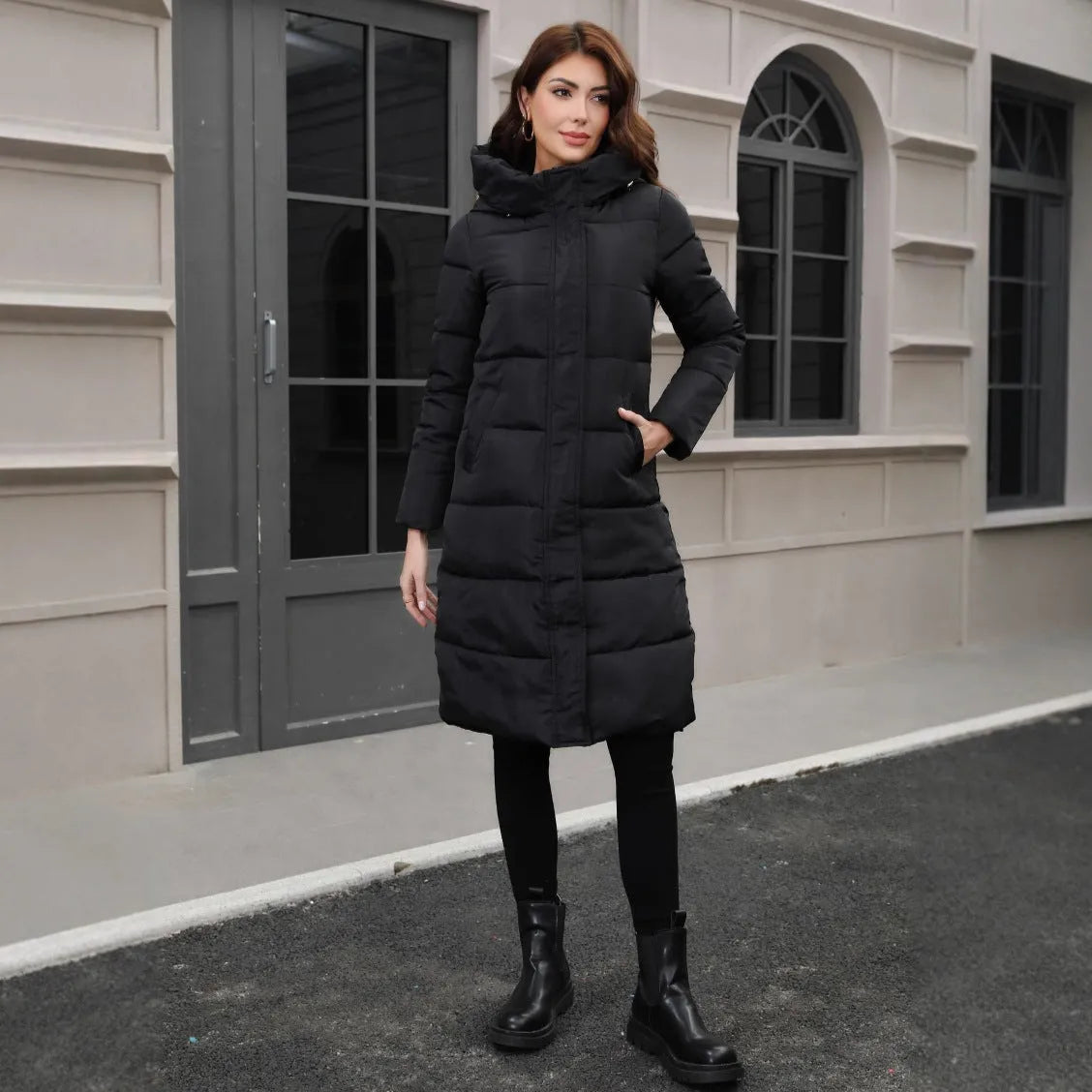 Black slim fit hooded jacket with long sleeves on a hanger.