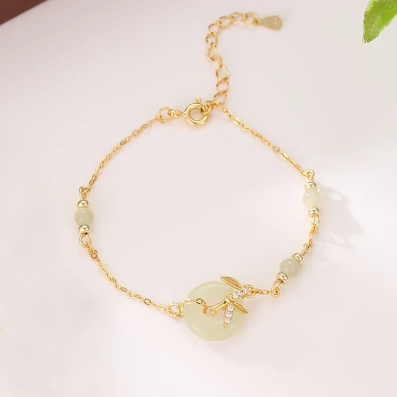 Women's antique style Hetian Jade bracelet with a silver safety buckle on a wrist.