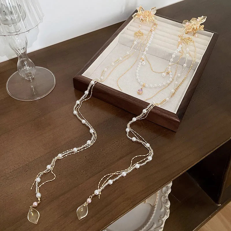 Gold-coloured women's hairpin with a pearl diamond flower decoration and a long acrylic tassel.