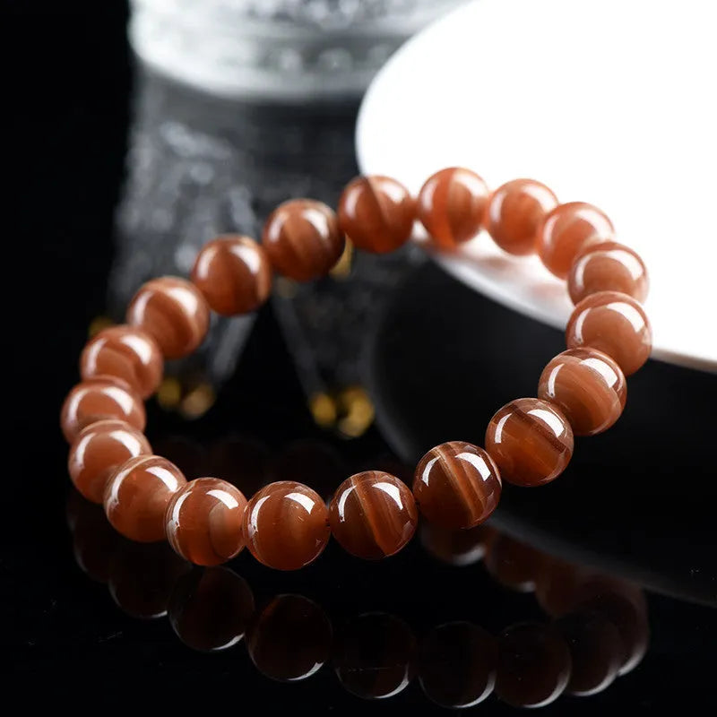 Natural Old Mine Rhodochrosite round bead bracelet from Peru showing pinkish-red mineral colour