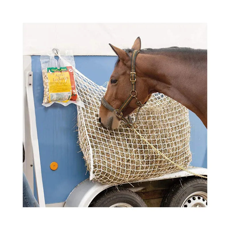 Black woven PE rope horse feeding bag with grid design hanging in stable