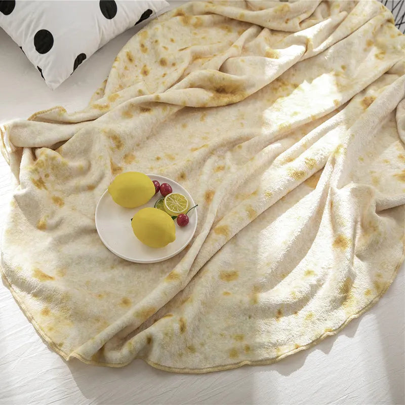 Round coral-coloured flannel burrito blanket with a delicious food print, folded to show soft texture.