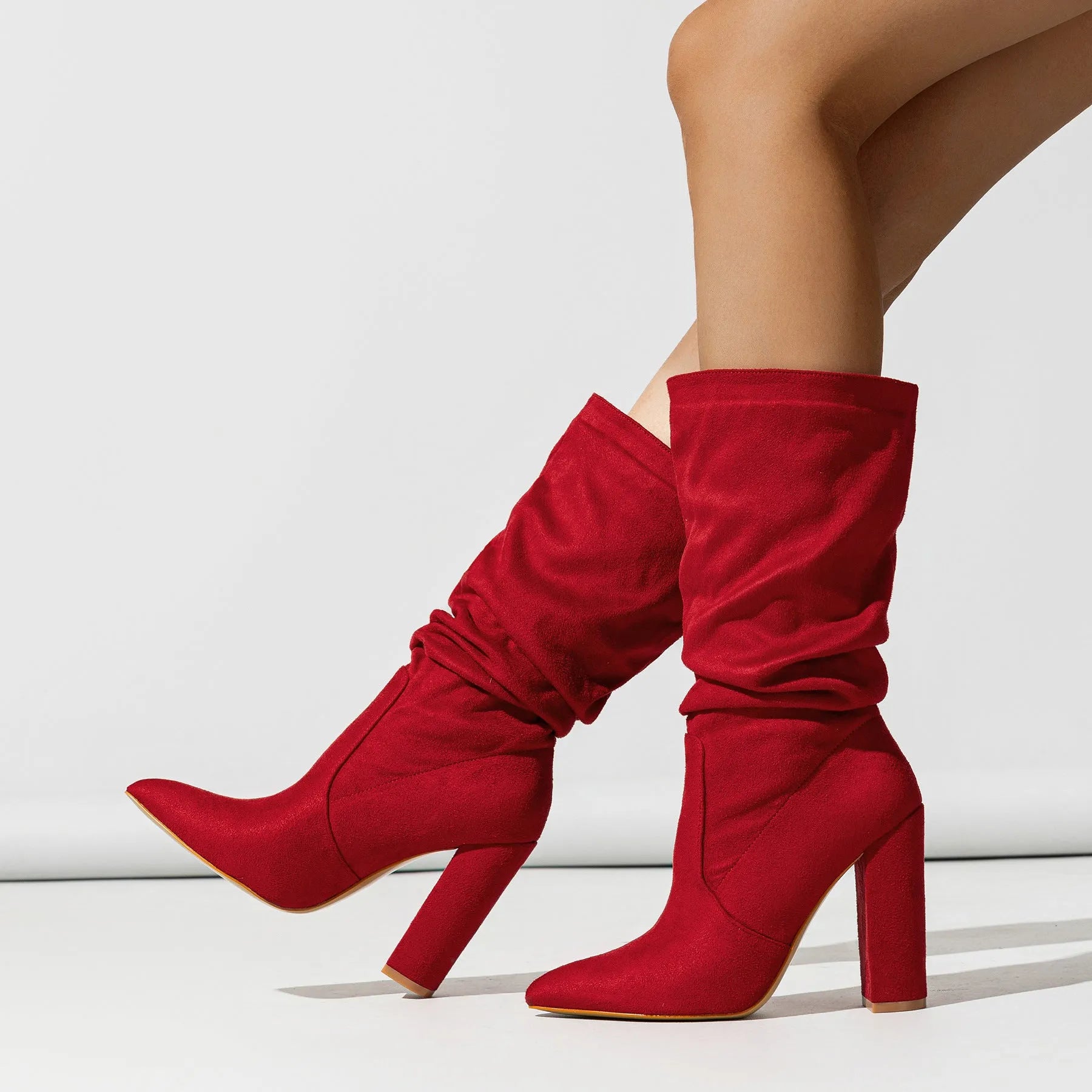 Women's black suede boots with chunky high heels and pointed toe design