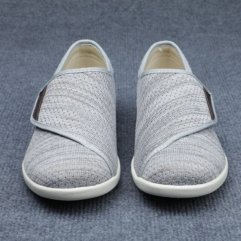 Beige and grey leisure shoes with a wide fit and a black velcro strap closure.