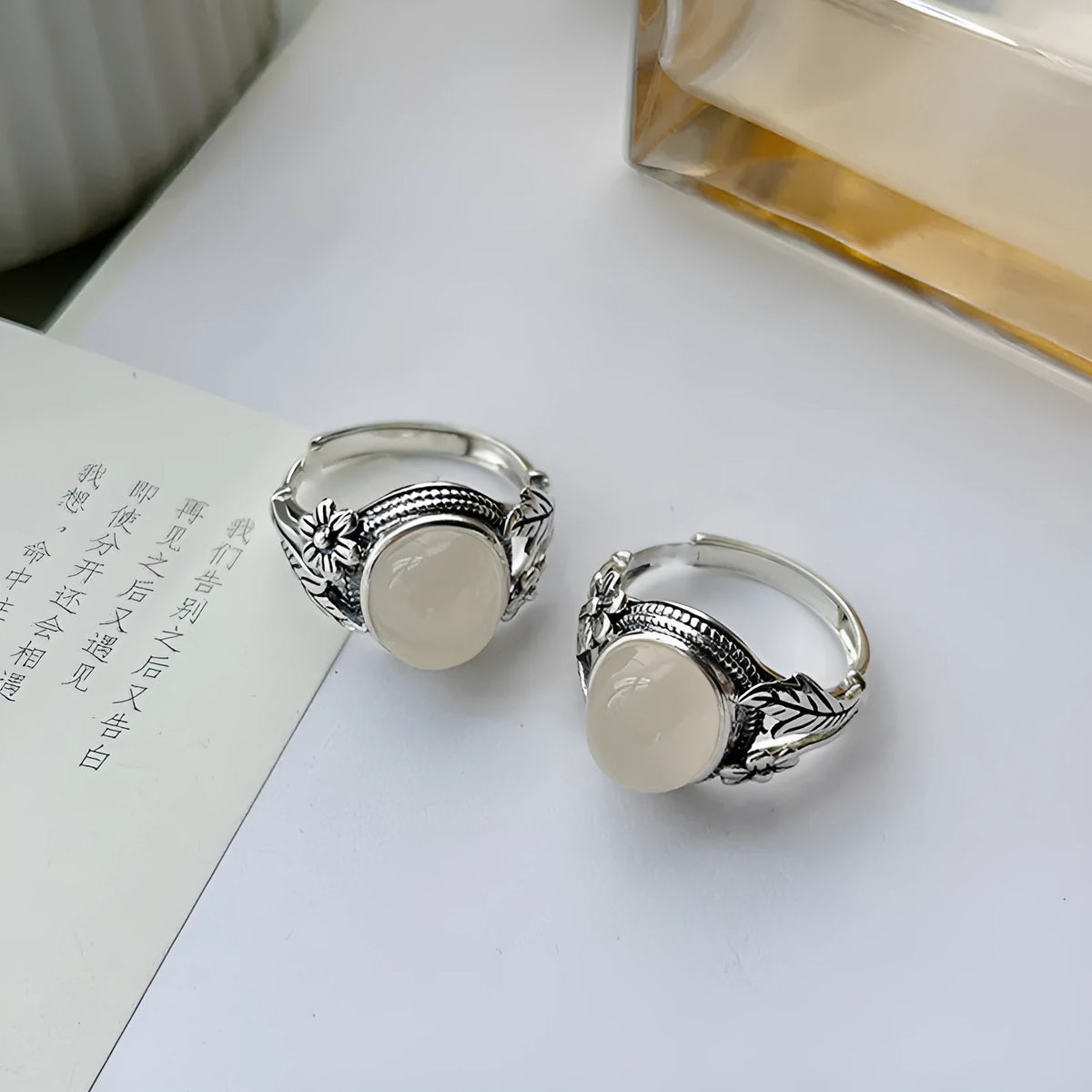 Antiqued copper ring with white stone and adjustable U-shaped opening.