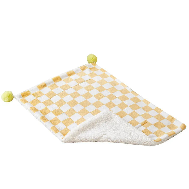 Green plaid plush fleece pet blanket with fur ball trim, laid flat as a dog bed or cat mat.