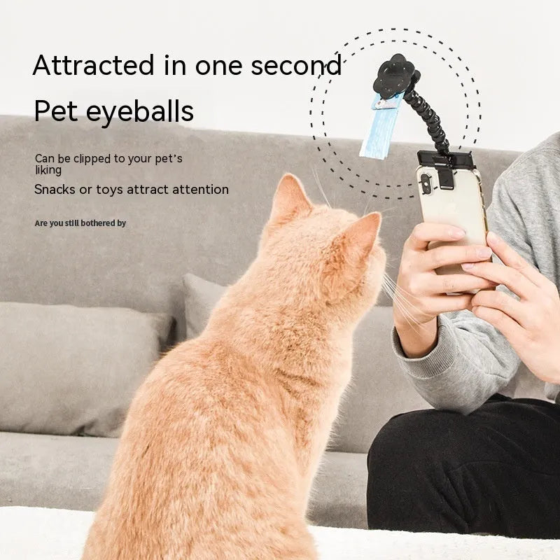 Black plastic pet photography tool with treat clip and phone holder, shown rotated to adjust angle.