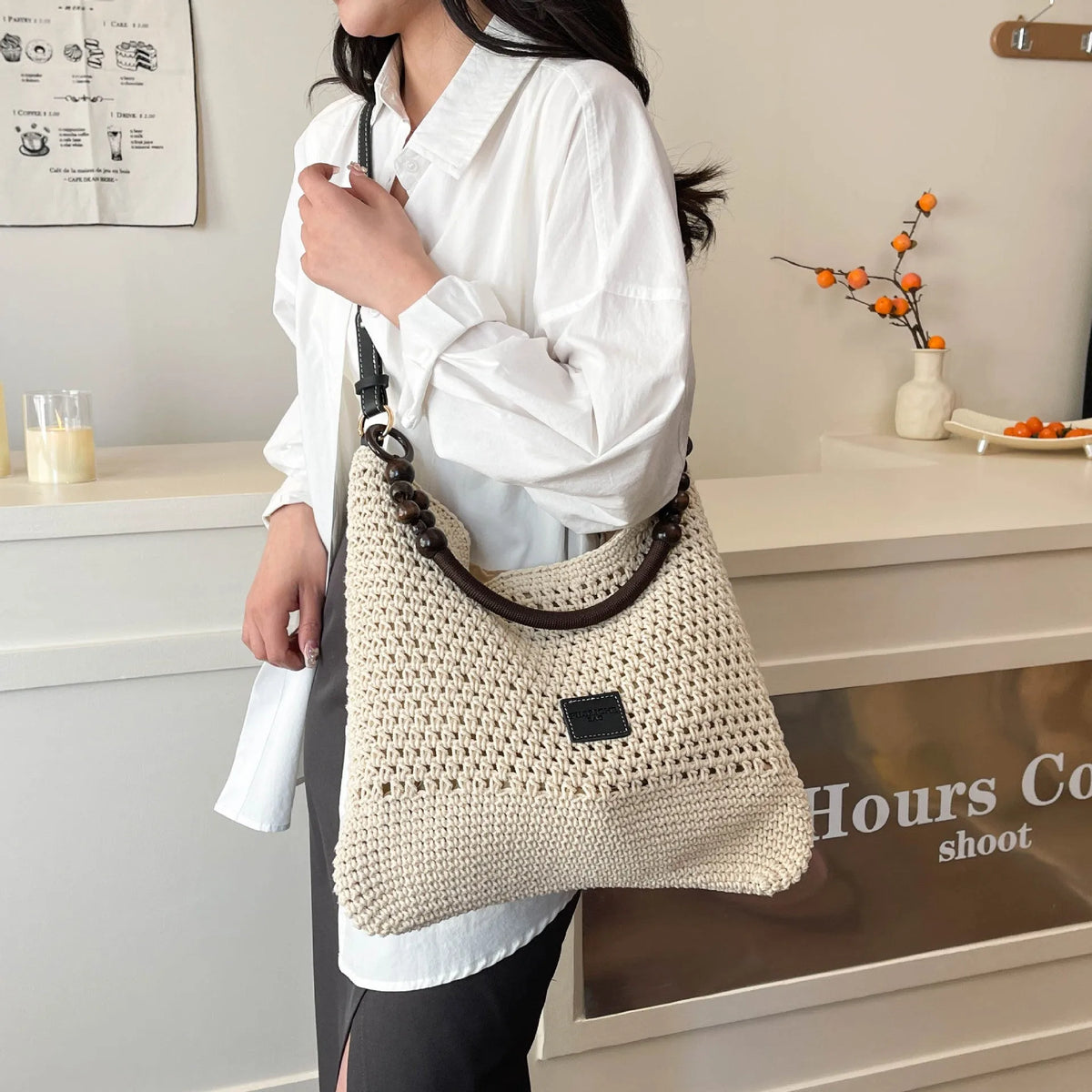 Black knitted bucket tote bag with contrast stitching showing internal zipper compartment