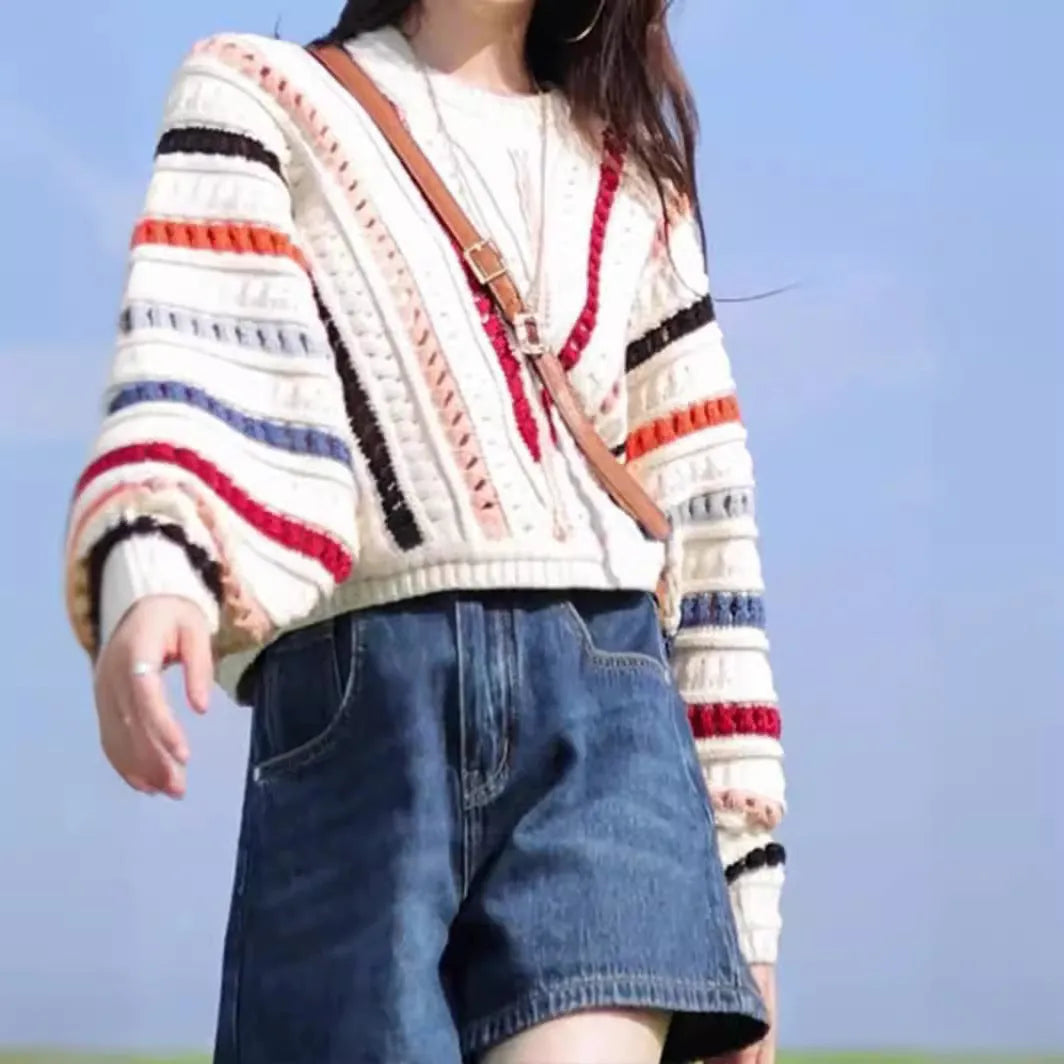 Round neck pullover sweater with rainbow stripes in hollow knit design featuring batwing sleeves