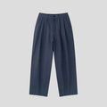 Men's apricot coloured loose-fit cotton linen trousers with a pencil leg on a plain background