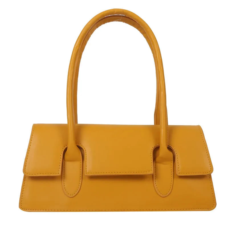 Women's black PU leather small square shoulder bag with stitching detail on a table.