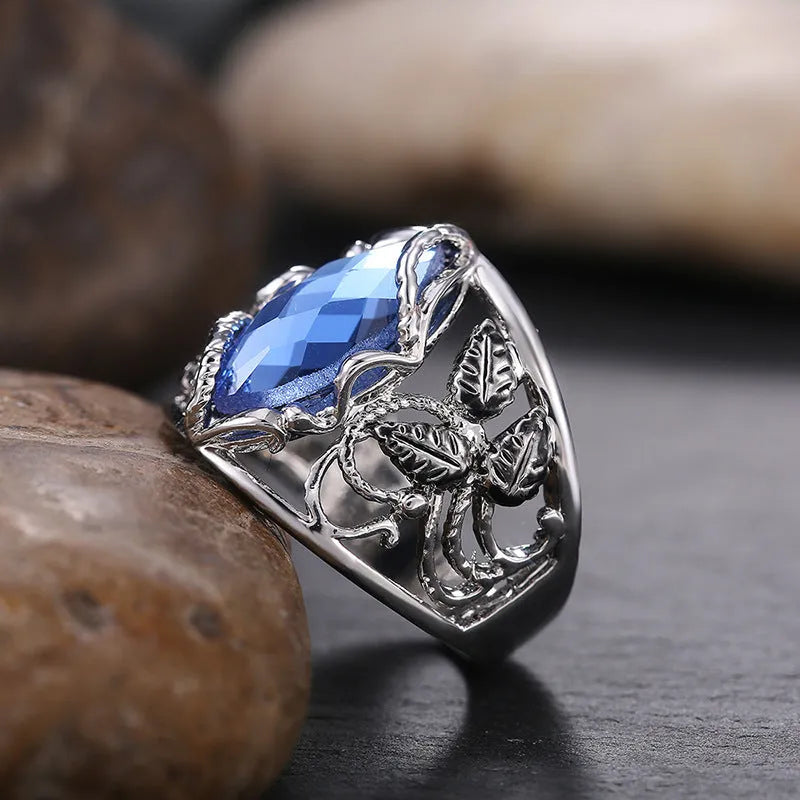 Blue horse eye-shaped crystal ring for women on a hand, showing geometric alloy design.