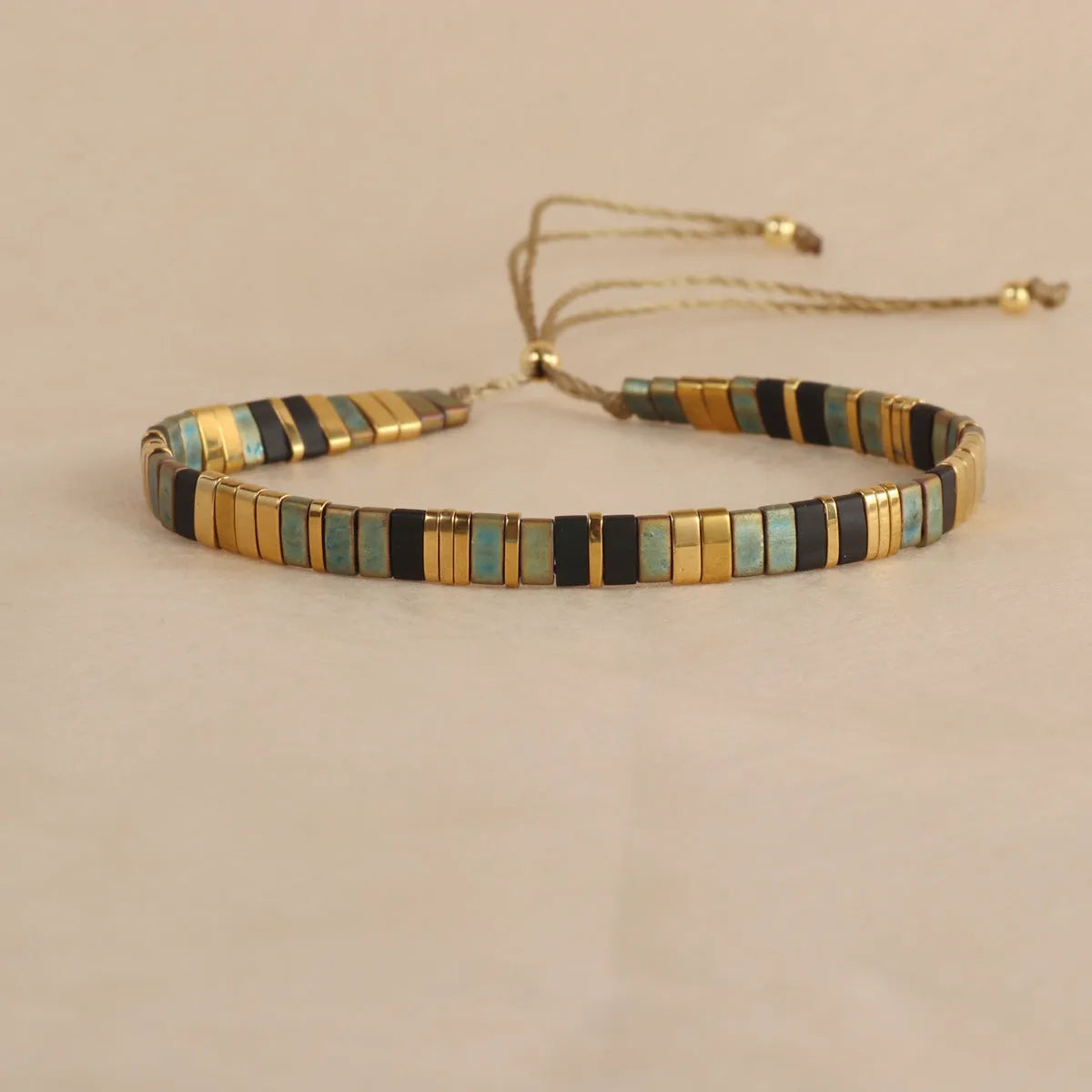 Geometric glass beaded bracelet in milky white, black, green, blue, or red on a white background.