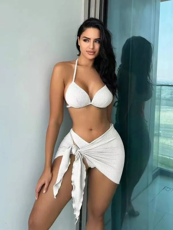 Women's black three-piece swimsuit set showing top, briefs, and skirt laid flat.