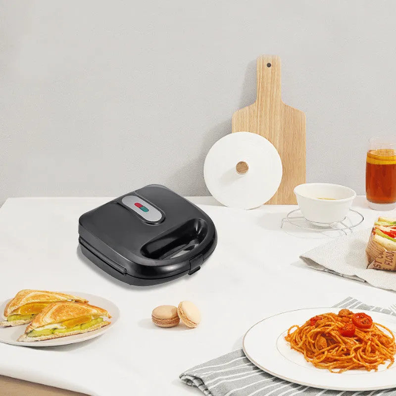 Black electric sandwich pan with double-sided heating, brushed stainless steel lid, and non-stick cooking plates.