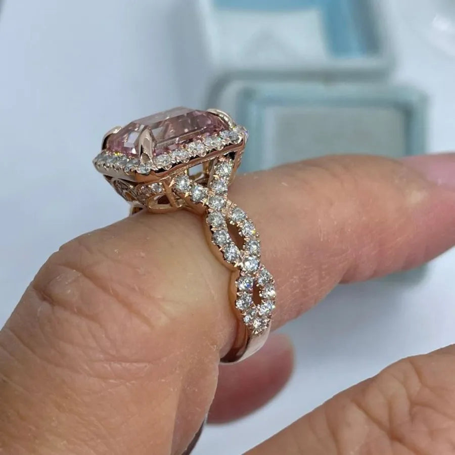 Geometric rose gold coloured alloy ring on a plain background.