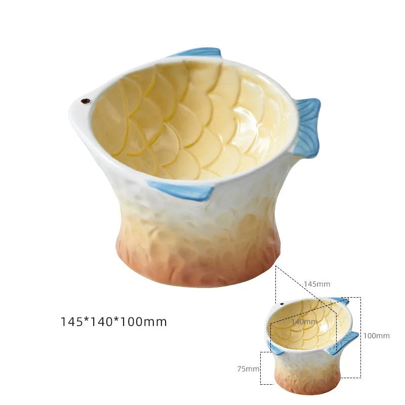 Four coloured fish-shaped ceramic cat bowls with tilted bases on a table.