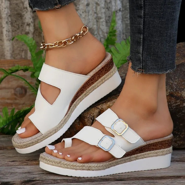 White casual wedge sandals with woven patent leather upper and peep toe design on a foot.