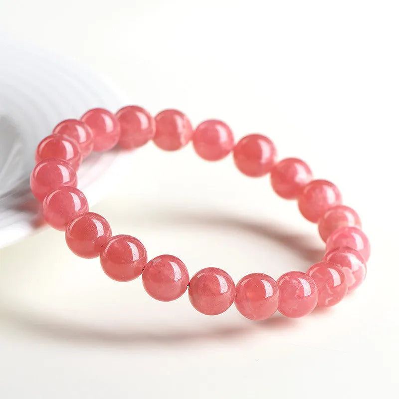 Women's geometric crystal bracelet with rhodochrosite pattern and a longevity lock charm.