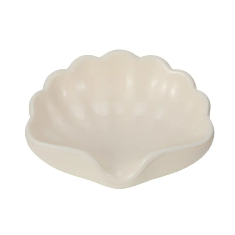 White plastic shell-shaped soap dish for bathroom countertop or wall.